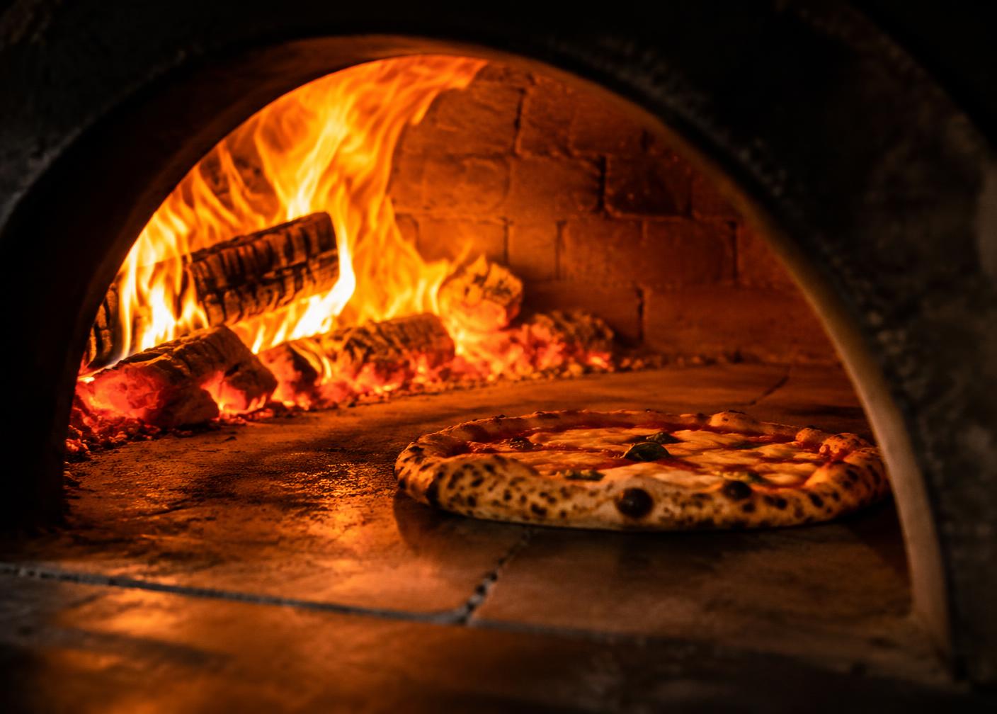Pizza im lodernden Holzofen